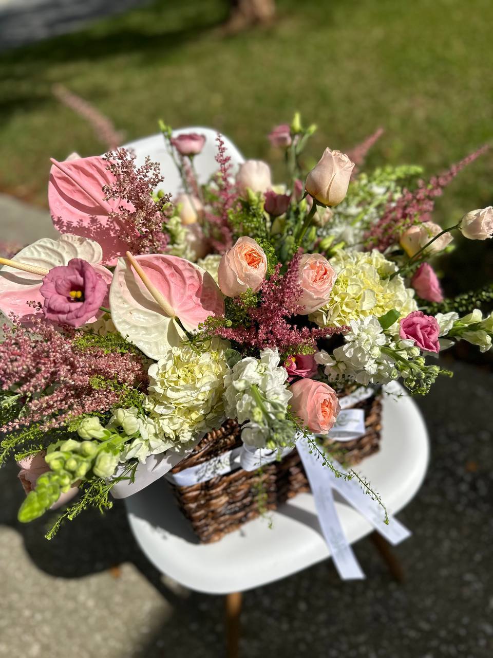 Bouquet of flowers on a white chair with a blurred outdoor background