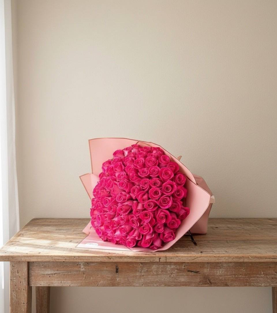 Bouquet of pink roses on a wooden table with a plain background