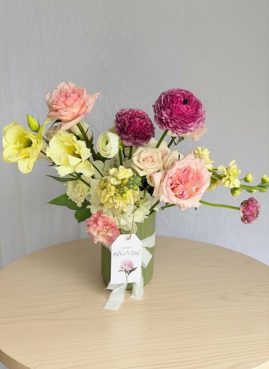 Bouquet of flowers with a tag on a wooden table against a gray background