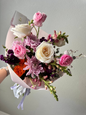 Bouquet of colorful flowers held against a plain background