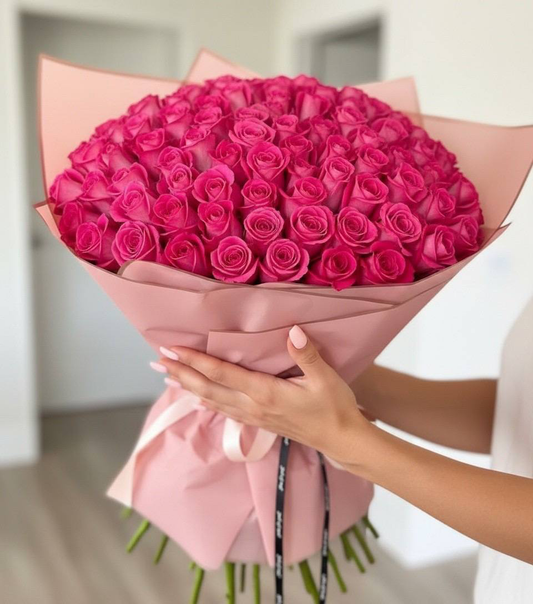 Bouquet of pink roses held by a person with a blurred background
